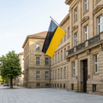 Ein historisches Regierungsgebäude in Baden-Württemberg mit schwarz-gelber Landesflagge steht für das neue Ladenöffnungsgesetz.